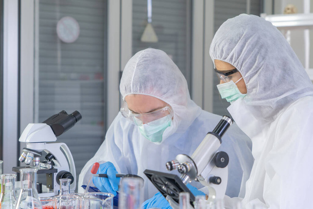 欧米の科学者は、技術医療、化学、医療、研究の研究室や研究室で、 covid-19ウイルスのワクチンの分析と開発のための試験管に取り組んでいます。実験科学. - 写真・画像