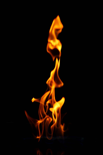 Gloeiend vuur vlam over zwarte achtergrond - Foto, afbeelding