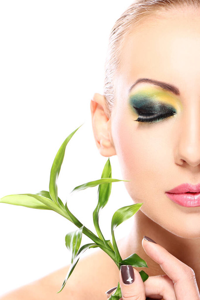 Όμορφη ξανθιά με καλλιτεχνικό μακιγιάζ και φύλλα μπαμπού - Φωτογραφία, εικόνα