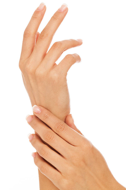 jonge vrouw handen met franse manicure over witte achtergrond - Foto, afbeelding