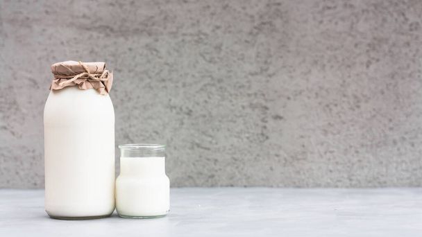 Fresh milk in a bottle on grey background. Kefir, milk or Turkish Ayran drink in a glass bottle. World milk day concept. Space for text. - Foto, afbeelding