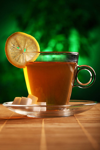 Tasse de thé vert chaud avec sucre et citron sur la table - Photo, image