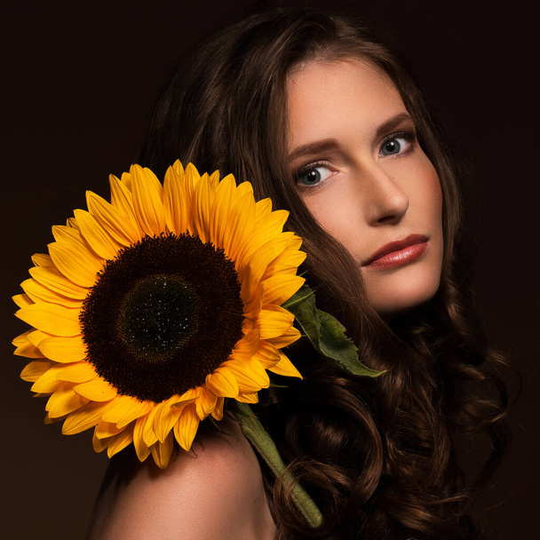 Very sexy young woman with a sunflower - Zdjęcie, obraz