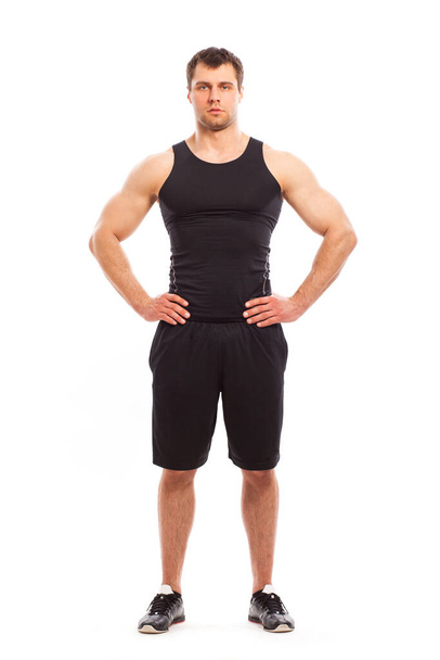 Bodybuilder in Fitwear posiert isoliert vor weißem Hintergrund - Foto, Bild