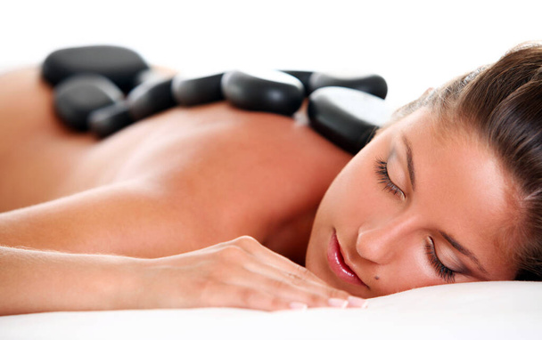 Beautiful woman enjoying a hot stone massage - Fotó, kép