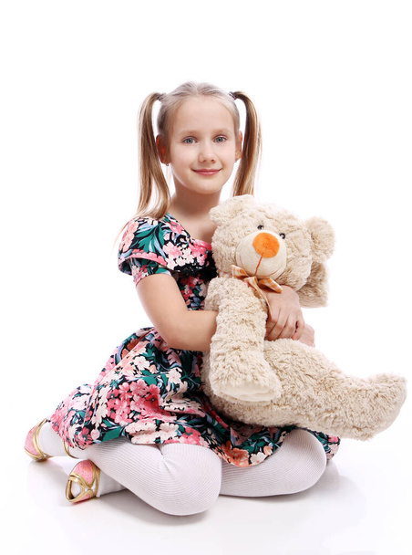 niedliches Mädchen mit ihrem Teddybär auf weißem Hintergrund - Foto, Bild