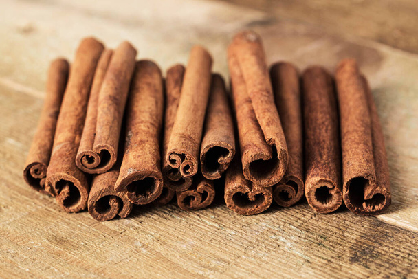 Stack of cinnamon wrapped with a rope over a wooden surface - Foto, Imagen