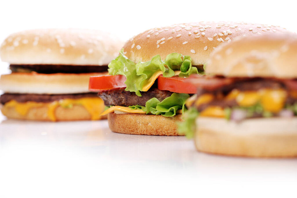 Big and tasty burgers over white background - Foto, afbeelding