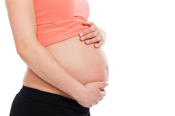 Mooie zwangere buik op een witte achtergrond - Foto, afbeelding