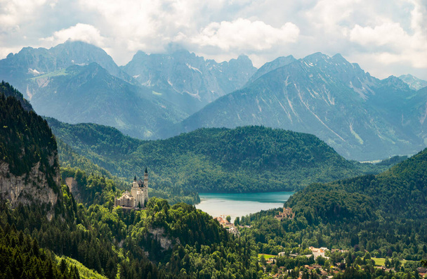 The Neuschwanstein Castle with the Bavarian Alps in the background - Foto, afbeelding