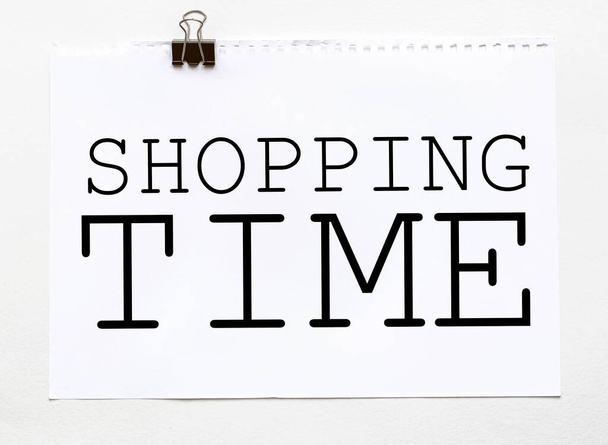 wit papier met tekst Shopping Time op een witte achtergrond met briefpapier - Foto, afbeelding