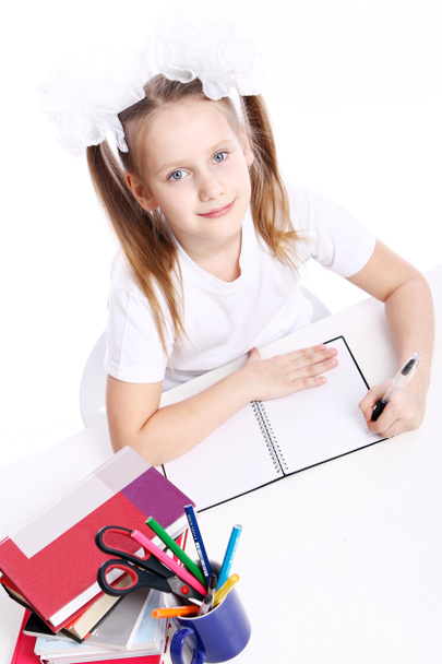 Cute little girl sitting at the desk - Photo, Image