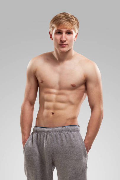 Handsome guy posing with naked torso over background - Photo, image