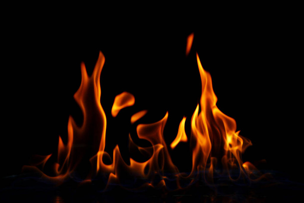 Glühende Feuerflamme über schwarzem Hintergrund - Foto, Bild