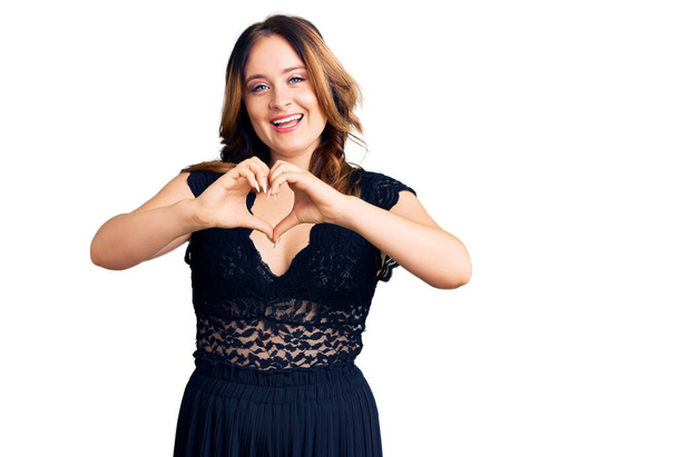 Young beautiful caucasian woman wearing elegant dress smiling in love showing heart symbol and shape with hands. romantic concept.  - Photo, Image