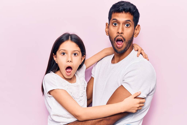 Jonge vader en dochter in casual kleding bang en geschokt met verrassende uitdrukking, angst en opgewonden gezicht.  - Foto, afbeelding