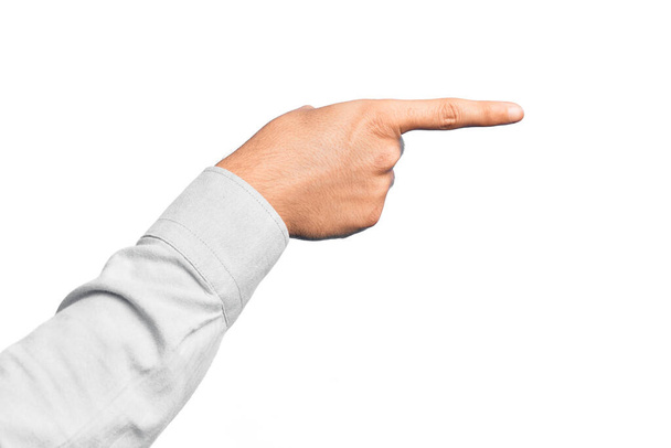 Hand van blanke jongeman met vingers over geïsoleerde witte achtergrond wijzend met wijsvinger naar de zijkant, wat een keuze suggereert en selecteert - Foto, afbeelding