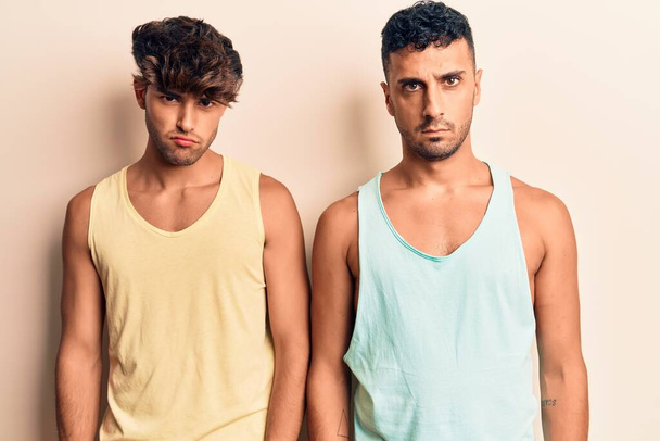 Mladý gay pár v neformálním oblečení skeptický a nervózní, zamračený kvůli problému. negativní osoba.  - Fotografie, Obrázek