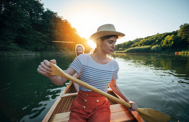 Giovane coppia che naviga in canoa sul tramonto del fiume  - Foto, immagini
