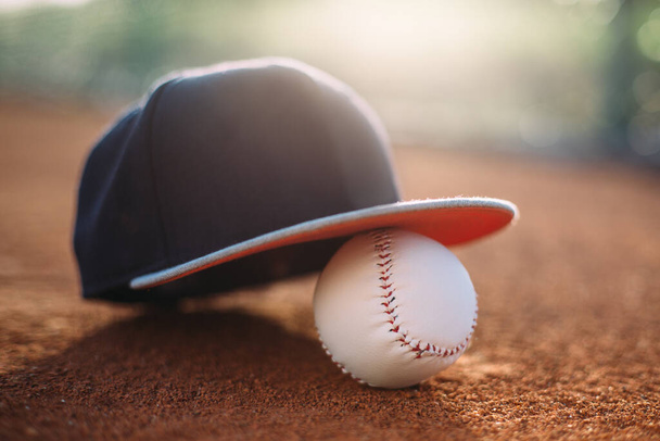 бейсбольна шапка і м'яч на полі
 - Фото, зображення