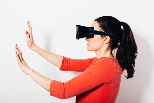 仮想現実の眼鏡をかける女性。VRヘッドセットを持つ女性のスタジオショット - 写真・画像