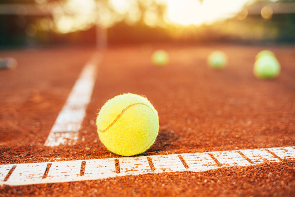 テニスコートのテニスボール。テニスコートのベースライン上のテニスボール - 写真・画像