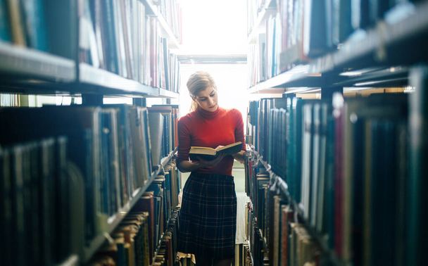 Young beautiful woman in the library - Photo, image