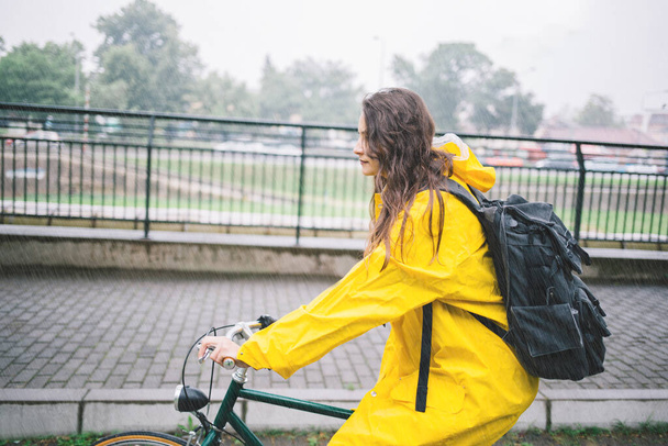 Nuori tyttö keltainen takki ratsastaa pyörä puistossa - Valokuva, kuva