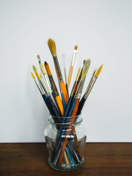 Paintbrushes in a jar at artist's studio - 写真・画像