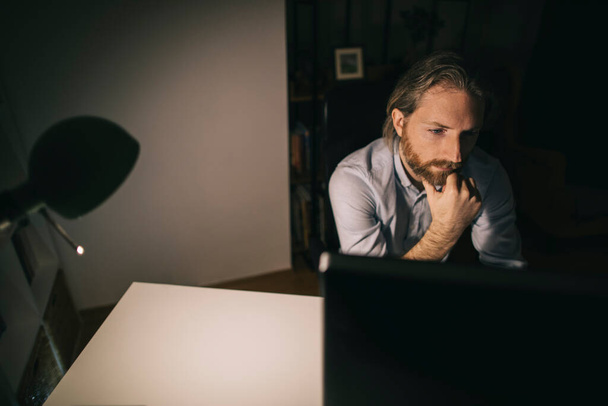 Man working long hours. Bearded man working on computer - Foto, afbeelding