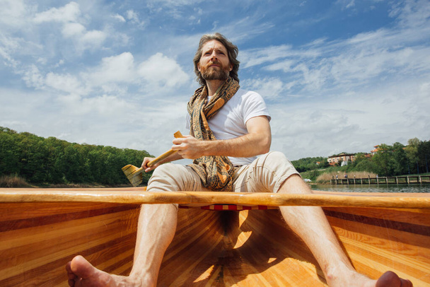 Komea parrakas mies purjehtii veneellä joella - Valokuva, kuva