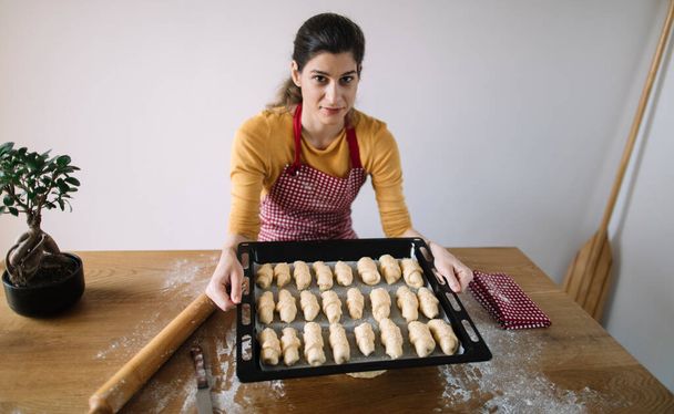 Une casserole de femme pleine de petits pains. Pâtisserie à petits pains maison - Photo, image