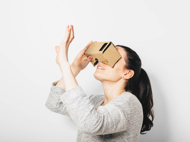 Femme utilisant un simulateur de casque de réalité virtuelle. Plan studio de jeune femme utilisant des lunettes de réalité virtuelle - Photo, image