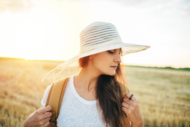 Молодая женщина в соломенной шляпе позирует в поле после сбора урожая - Фото, изображение