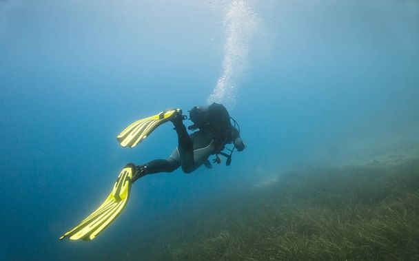 Homme plongeant sous l'eau avec fond rocheux - Photo, image