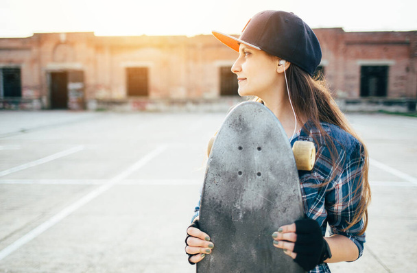 jong tiener meisje met skateboard, buiten - Foto, afbeelding