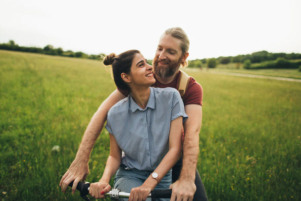 Couple drôle faire du vélo sur le terrain d'été  - Photo, image