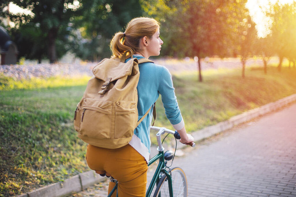 Молода дівчина їде на велосипеді в парку
 - Фото, зображення