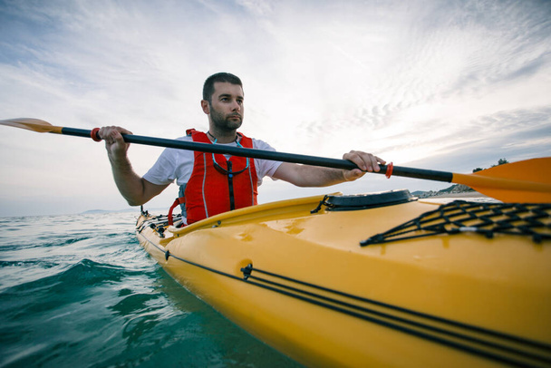 Uomo kayak su un mare calmo acqua all'alba - Foto, immagini