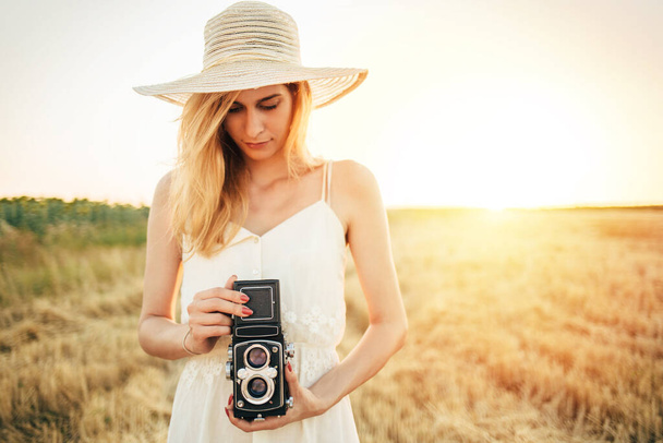 若い女性写真家が夏の瞬間を捉える。女の子とともにヴィンテージ中判カメラ  - 写真・画像
