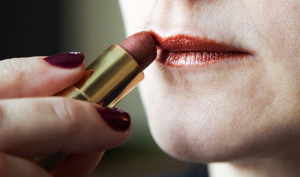 Woman paints lips with lipstick - Zdjęcie, obraz