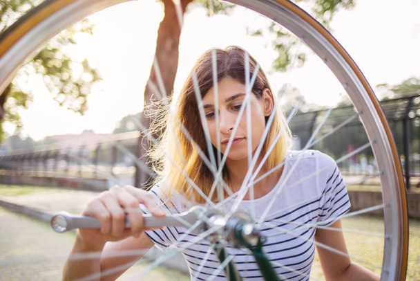 κορίτσι επισκευή ποδήλατο από κοντά   - Φωτογραφία, εικόνα