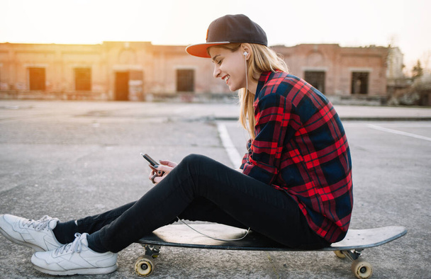Young teenager girl with skateboard, outdoors - Fotó, kép