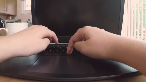 Cerca de alguien escribiendo en un ordenador portátil, ya que trabajan desde casa en una cocina doméstica - Metraje, vídeo