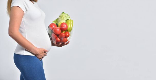 Pregnant woman and fresh vegetables in glass bowl - Foto, immagini