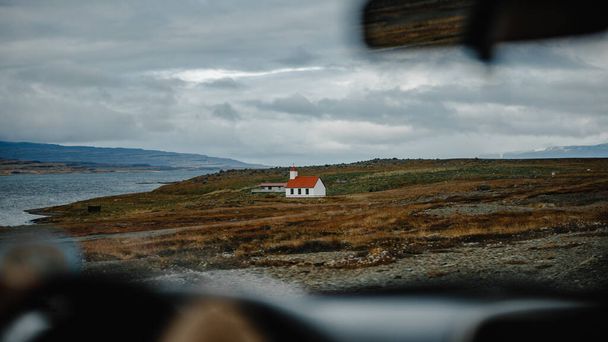 A selective focus shot of a little house on the hill captured from the car - Zdjęcie, obraz