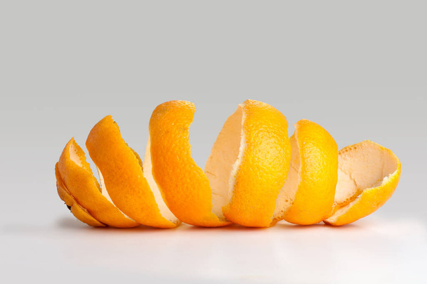 Peel of an orange spiral. twist on the peel. on gray background - Foto, Bild