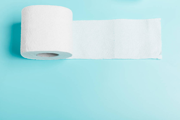 Roll of white toilet white paper on a blue background. Top view. The concept of hygiene, cleanliness - Photo, Image