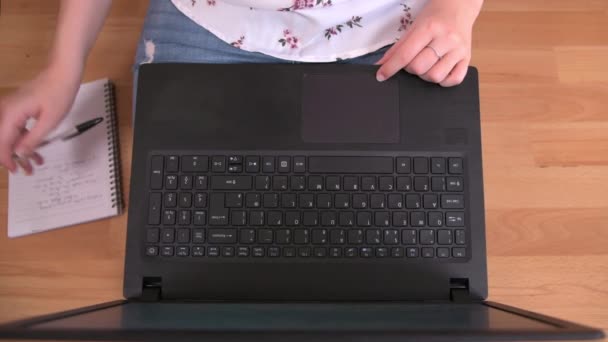 A padlón ülő személy otthonról dolgozik, jegyzetel és gépel a laptopján - Felvétel, videó