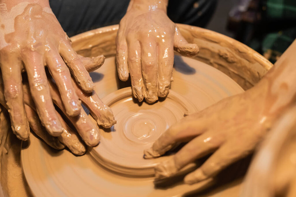 detail-up rukou ženy a dítěte v hlíně v keramické dílně. - Fotografie, Obrázek